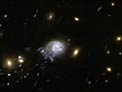 Hubble sees "Comet Galaxy" being ripped apart by galaxy cluster